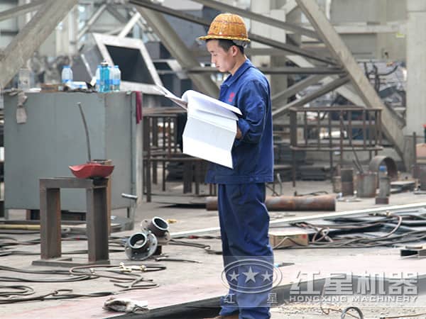 工人正在認(rèn)真對(duì)比圖紙